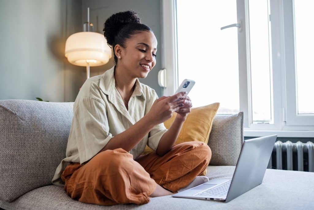 Teen Using Cell Phone and Laptop